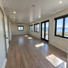 Light gray modular homes workforce housing trailer with black windows, wooden floor, and scenic lake view. — supplier listing reference; configuration may vary.